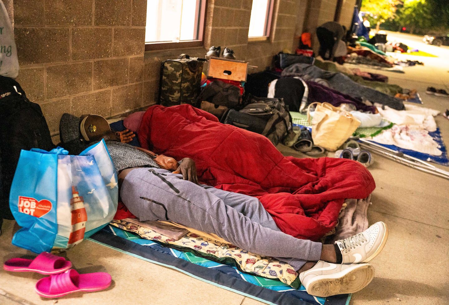 Odrick Dorcias, 28, a Haitian migrant, prepared to stay overnight with others outside the Wollaston T stop on Aug. 26.