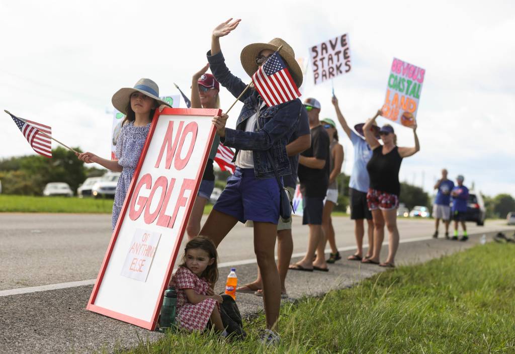 A large crowd of people gather at the front entrance of Jonathan Dickinson State Park to protest against the proposed golf courses Saturday, Aug. 24, 2024, in Martin County. Florida 