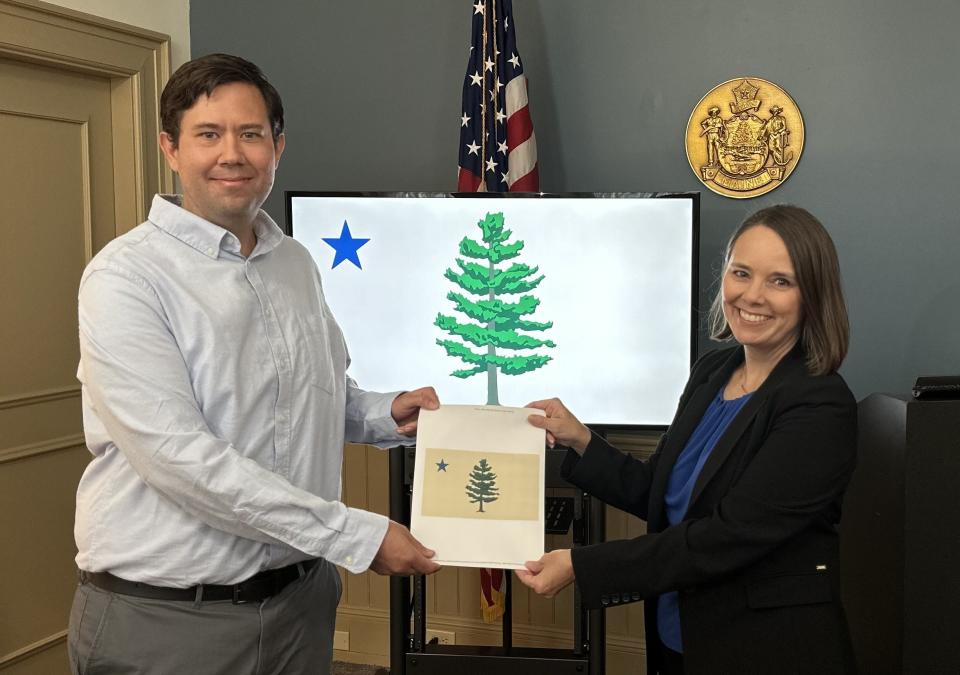 Adam Lemire of Gardiner was selected Monday as the winner of the Maine State Flag Redesign Contest. Lemire is pictured with Maine Secretary of State Shenna Bellows.