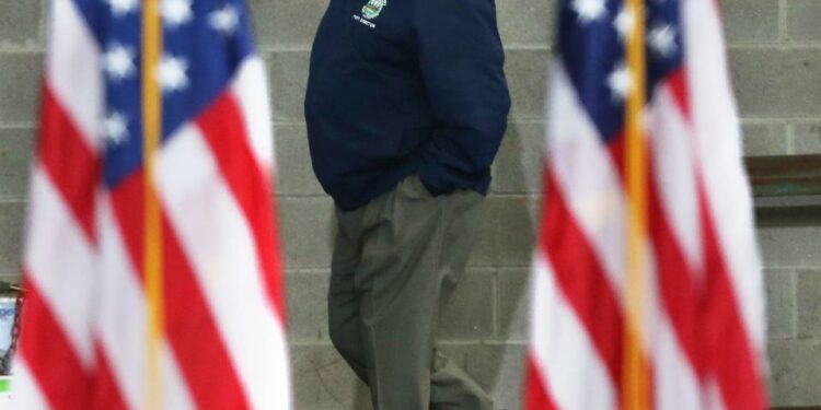 Geno Marconi walks between American flags during President Joe Biden's visit to the New Hampshire Port Authority in Porstmouth April 19, 2022.