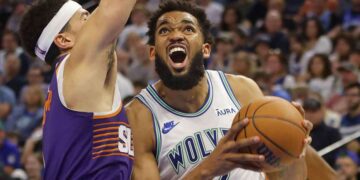 Minnesota Timberwolves forward Karl-Anthony Towns (32) works around Phoenix Suns guard Devin Booker (1) in the third quarter at Target Center.