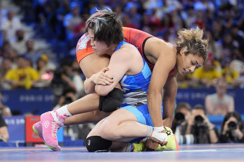 Kennedy Alexis Blades, of the United States, and Japan's Yuka Kagami, in blue, compete in their women's freestyle 76kg final wrestling match, at Champ-de-Mars Arena, during the 2024 Summer Olympics, Sunday, Aug. 11, 2024, in Paris, France. (AP Photo/Eugene Hoshiko)