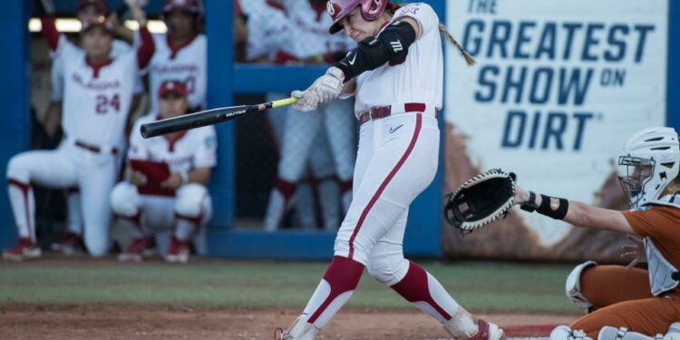 Jun 5, 2024; Oklahoma City, OK, USA; Oklahoma Sooners catcher Kinzie Hansen (9) hits a two run home run in the third inning against the Texas Longhorns during game one of the Women's College World Series softball championship finals at Devon Park. Mandatory Credit: Brett Rojo-USA TODAY Sports