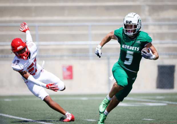 Lincoln's Ty Olsen, right, runs the ball against Las Vegas Arbor View's Izaiah Lekuti during their game at Southwestern College on Saturday, Aug. 24, 2024 in Chula Vista, CA. (Meg McLaughlin / The San Diego Union-Tribune)