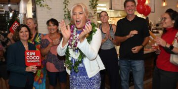 Hawaii House candidate Kim Coco Iwamoto reacts to the first printout of the Democratic Party primary election at a coffee shop in Kakaako on Saturday. (Marco Garcia/Civil Beat/2024)