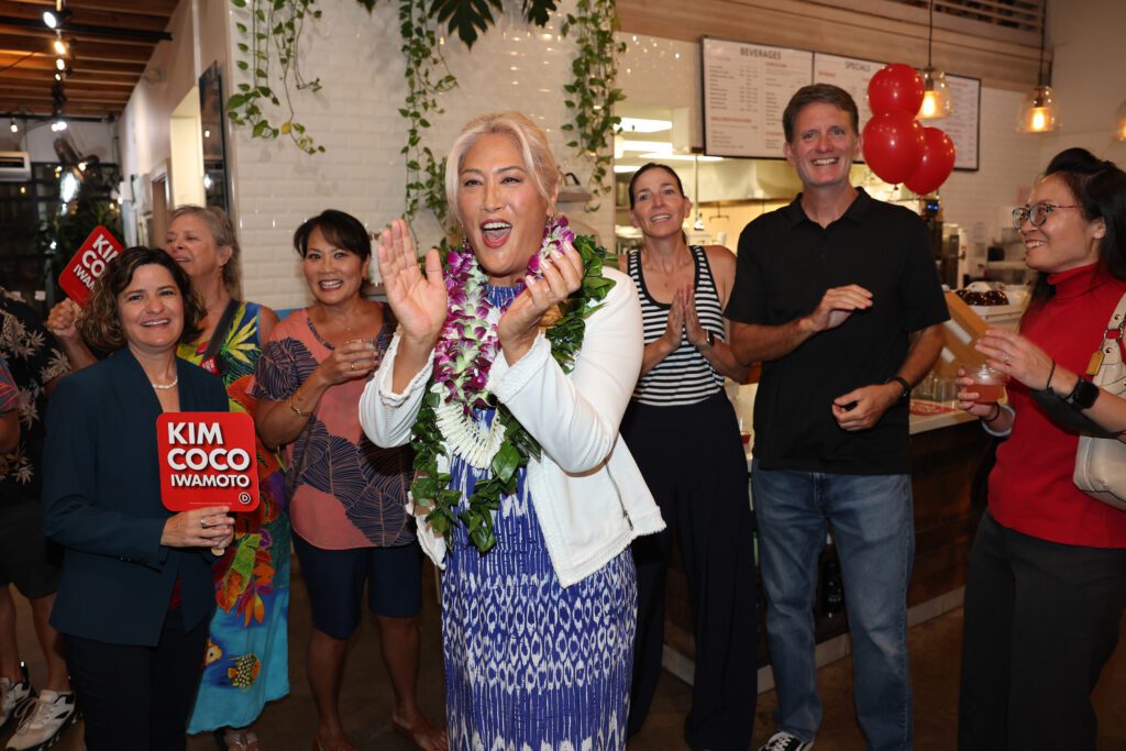 Hawaii House candidate Kim Coco Iwamoto reacts to the first printout of the Democratic Party primary election at a coffee shop in Kakaako on Saturday. (Marco Garcia/Civil Beat/2024)