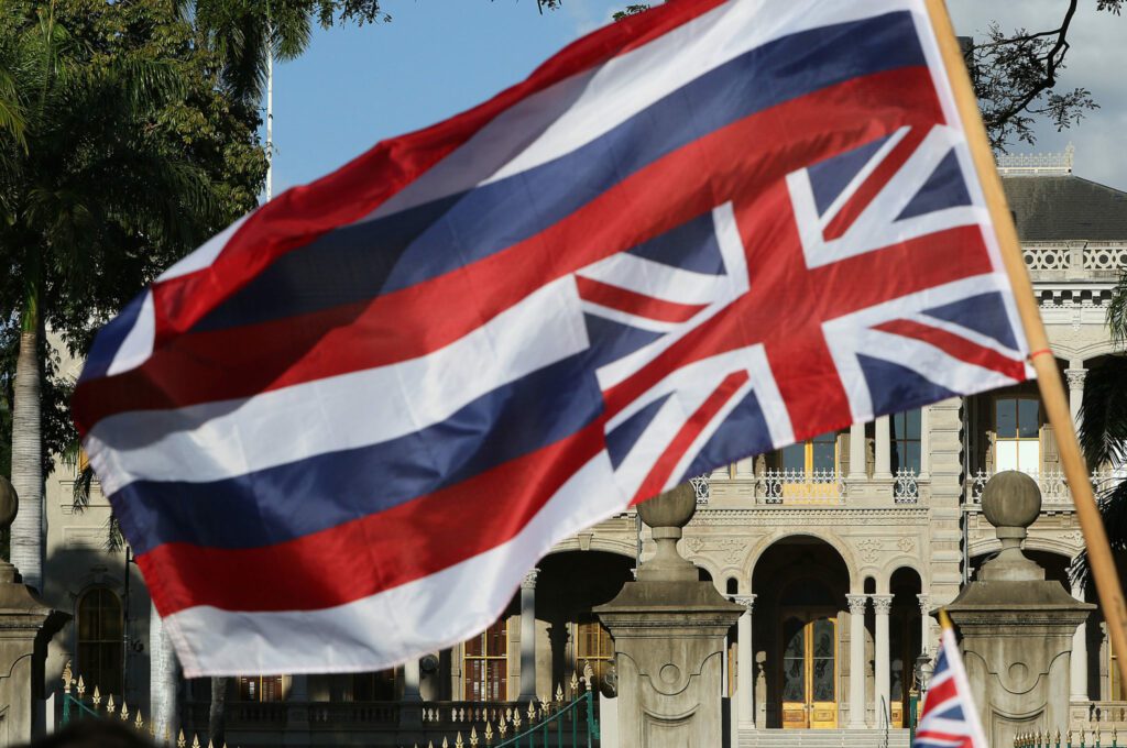 Demonstrators wave an upside down Hawaiian Flag along King Street near Iolani Palace.