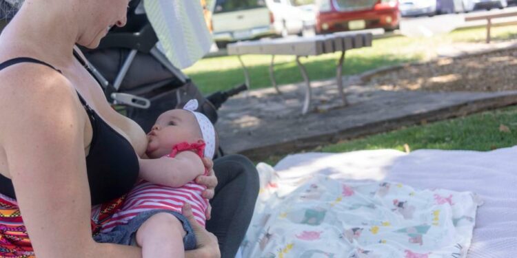 Darby Cline with her 4 month old baby Zaliyah Jewell-borquez, feeding breast milk while several moms came to support Nationwide Nurse-In Arizona 2019 at Rose Garden beside Arizona State Capitol on April 26, 2019.