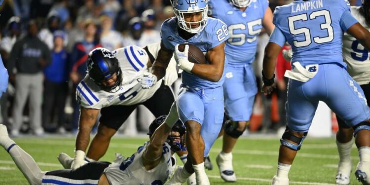 Nov 11, 2023; Chapel Hill, North Carolina, USA; North Carolina Tar Heels running back Omarion Hampton (28) with the ball as Duke Blue Devils linebacker Nick Morris Jr. (36) defends in the first quarter at Kenan Memorial Stadium. Mandatory Credit: Bob Donnan-USA TODAY Sports