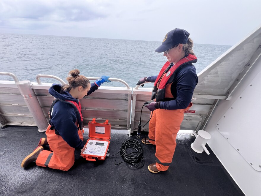 Elia Betschen, left, and Jessie Matthews, right, prepare to retrieve a passive acoustic monitor from the Gulf of Maine during a recent surveillance trip.