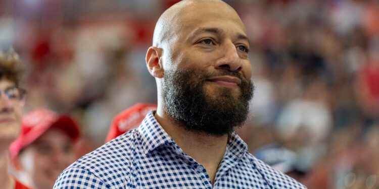 Royce White, candidate for U.S. Senate, listens as Republican presidential candidate former President Donald Trump speaks at a campaign rally, Saturday, July 27, 2024, in St. Cloud, Minn.