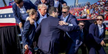 U.S. Secret Service agents remove Donald Trump from the stage.