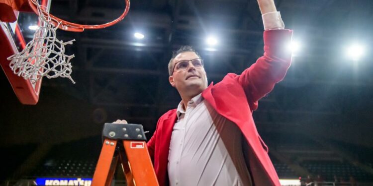 Bradley Braves head coach Brian Wardle holds up a piece of net for the crowd after cutting it down in celebration of winning the MVC championship with a 73-61 defeat of Drake on Sunday, Feb. 26, 2023 at Carver Arena.