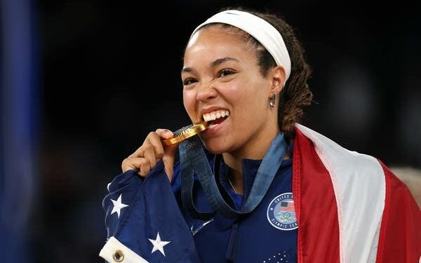 a woman bites a medal