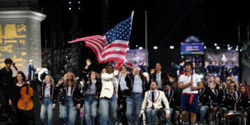 Nicky Nieves and Steve Serio, Flag Bearers of Team United States, hold their national flag as they parade during the opening ceremony of the Paris 2024 Summer Paralympic Games at Place de la Concorde on August 28, 2024 in Paris, France.