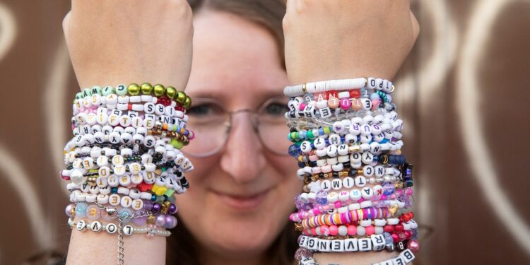 A young person with wrists full of bracelts.