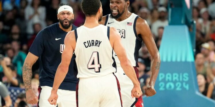 Kevin Durant, right, Steph Curry (4) and Anthony Davis, left, of the United States celebrate during the second half of their semifinal game against Serbia during the Paris Olympics at Accor Arena in Paris on Aug. 8, 2024.