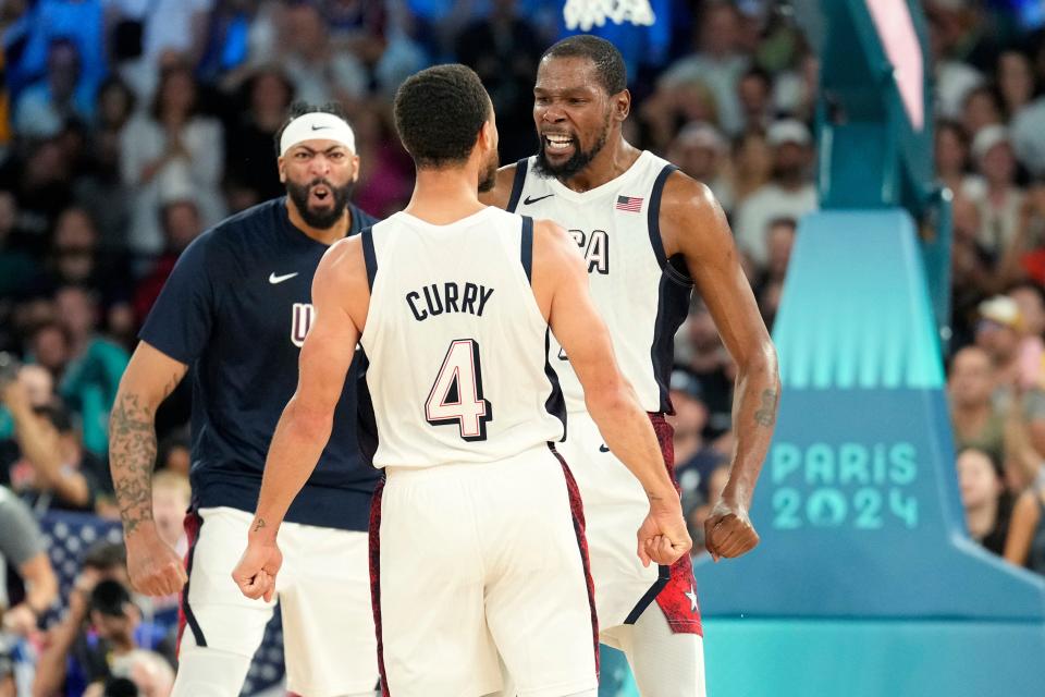 Kevin Durant, right, Steph Curry (4) and Anthony Davis, left, of the United States celebrate during the second half of their semifinal game against Serbia during the Paris Olympics at Accor Arena in Paris on Aug. 8, 2024.