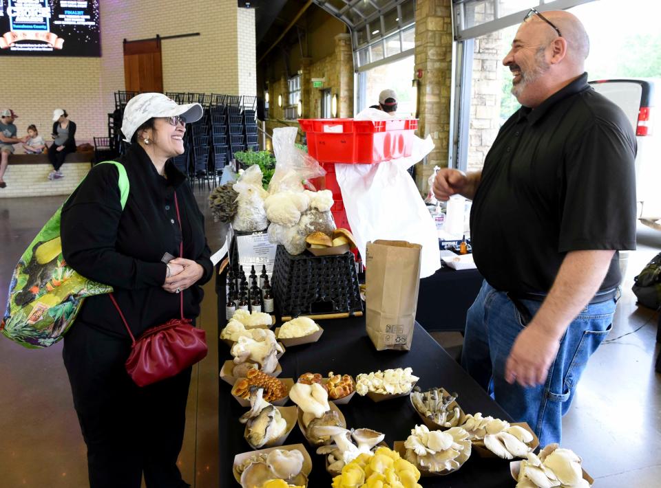 April 20, 2024; Tuscaloosa, AL, USA; Patrons peruse the produce and other products at the Tuscaloosa Farmers Market Saturday at Tuscaloosa River Market. Alka Wells talks with Martin Blair, the Mushroom Man, as he sells freshly grown mushrooms.