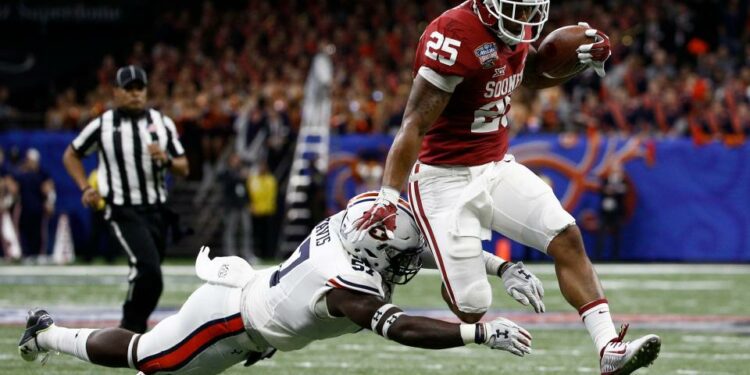 Jan 2, 2017; New Orleans , LA, USA; Oklahoma Sooners running back Joe Mixon (25) leaps away from the tackle attempt of Auburn Tigers linebacker Deshaun Davis (57) in the second quarter of the 2017 Sugar Bowl at the Mercedes-Benz Superdome. Mandatory Credit: Derick E. Hingle-USA TODAY Sports