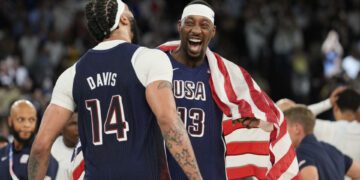 United States' Anthony Davis (14) and United States' Bam Adebayo (13) celebrate after beating France to win the gold medal during a men's gold medal basketball game at Bercy Arena at the 2024 Summer Olympics, Saturday, Aug. 10, 2024, in Paris, France. (AP Photo/Rebecca Blackwell)