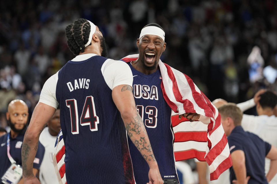 United States' Anthony Davis (14) and United States' Bam Adebayo (13) celebrate after beating France to win the gold medal during a men's gold medal basketball game at Bercy Arena at the 2024 Summer Olympics, Saturday, Aug. 10, 2024, in Paris, France. (AP Photo/Rebecca Blackwell)