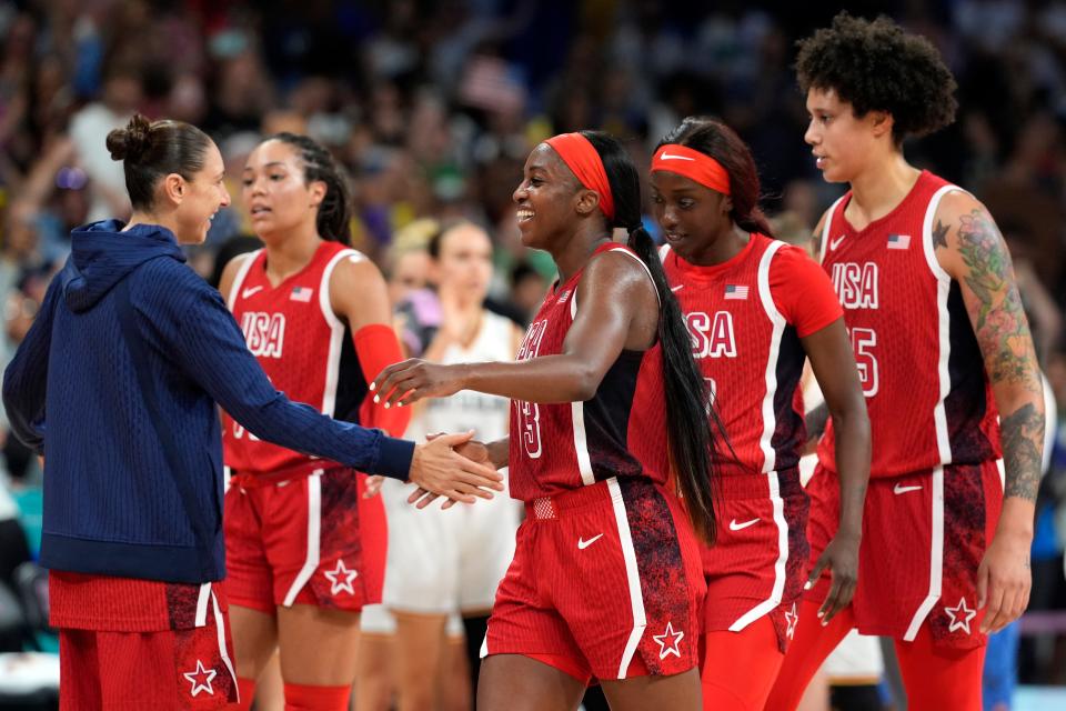 U.S. shooting guard Diana Taurasi (12) celebrates with forward guard Jackie Young (13) and forward Kahleah Copper (7) and centre Brittney Griner (15) after defeating Germany in a women's group C game during the Paris 2024 Olympic Summer Games at Stade Pierre-Mauroy.