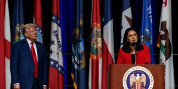 Republican presidential nominee and former U.S. President Donald Trump listens as former Democratic presidential candidate Tulsi Gabbard speaks at the National Guard of the United States General Conference in Detroit, Michigan U.S., August 26, 2024.