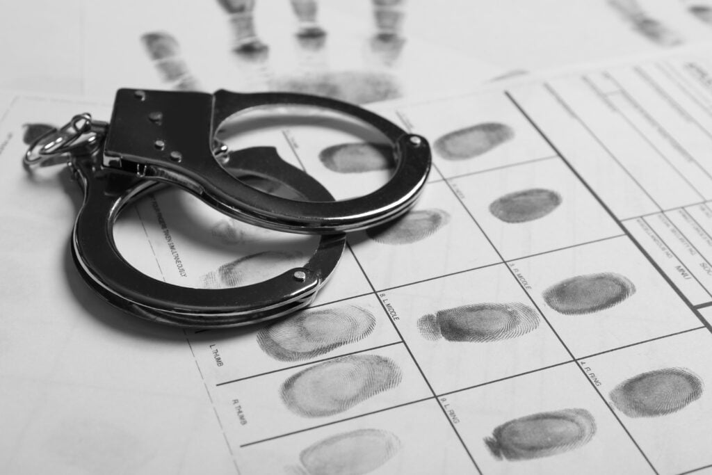 Police handcuffs and criminal fingerprints card