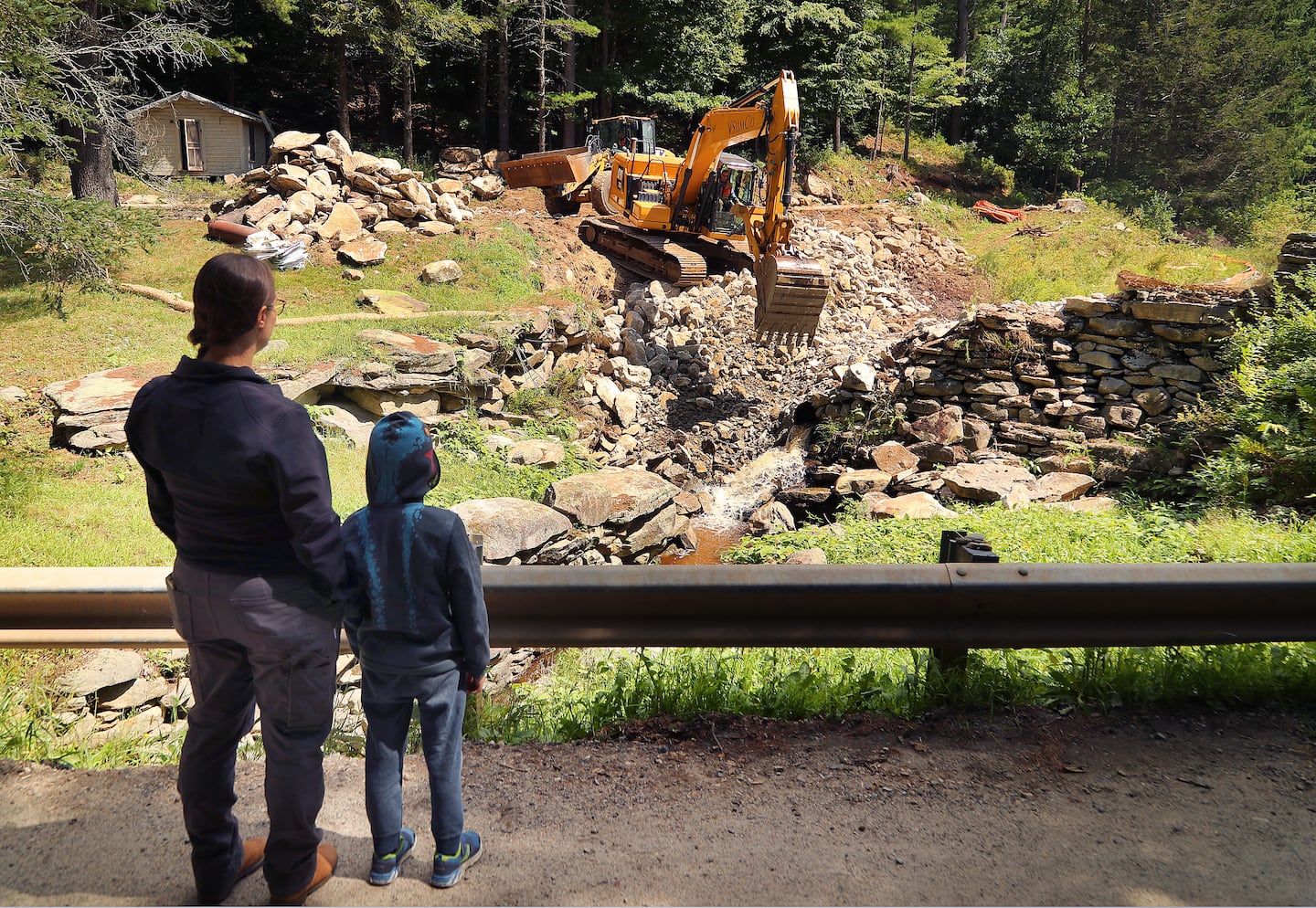 The old Dudleyville Pond Dam was taken down by heavy construction equipment after an emergency order because of a high risk of failure. Erin Jacque watched the removal of the dam with her son, Xavier, 7. She helped dam owner Lois Brown with the process of getting it taken down.