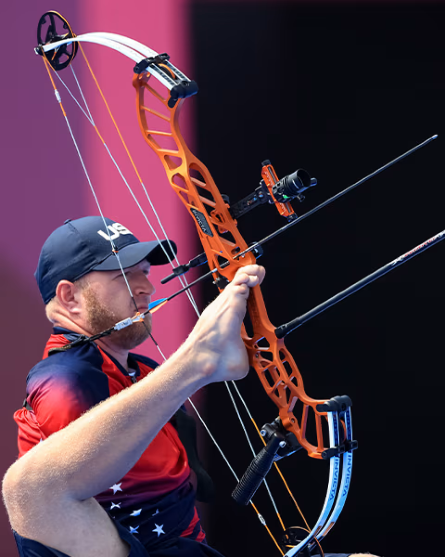 Matt Stutzman shoots a bow from a seated position using his foot.