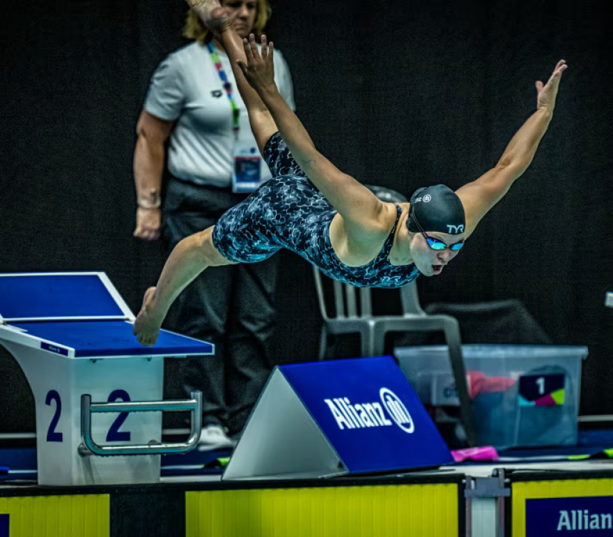 Olivia Chambers dives into a pool.