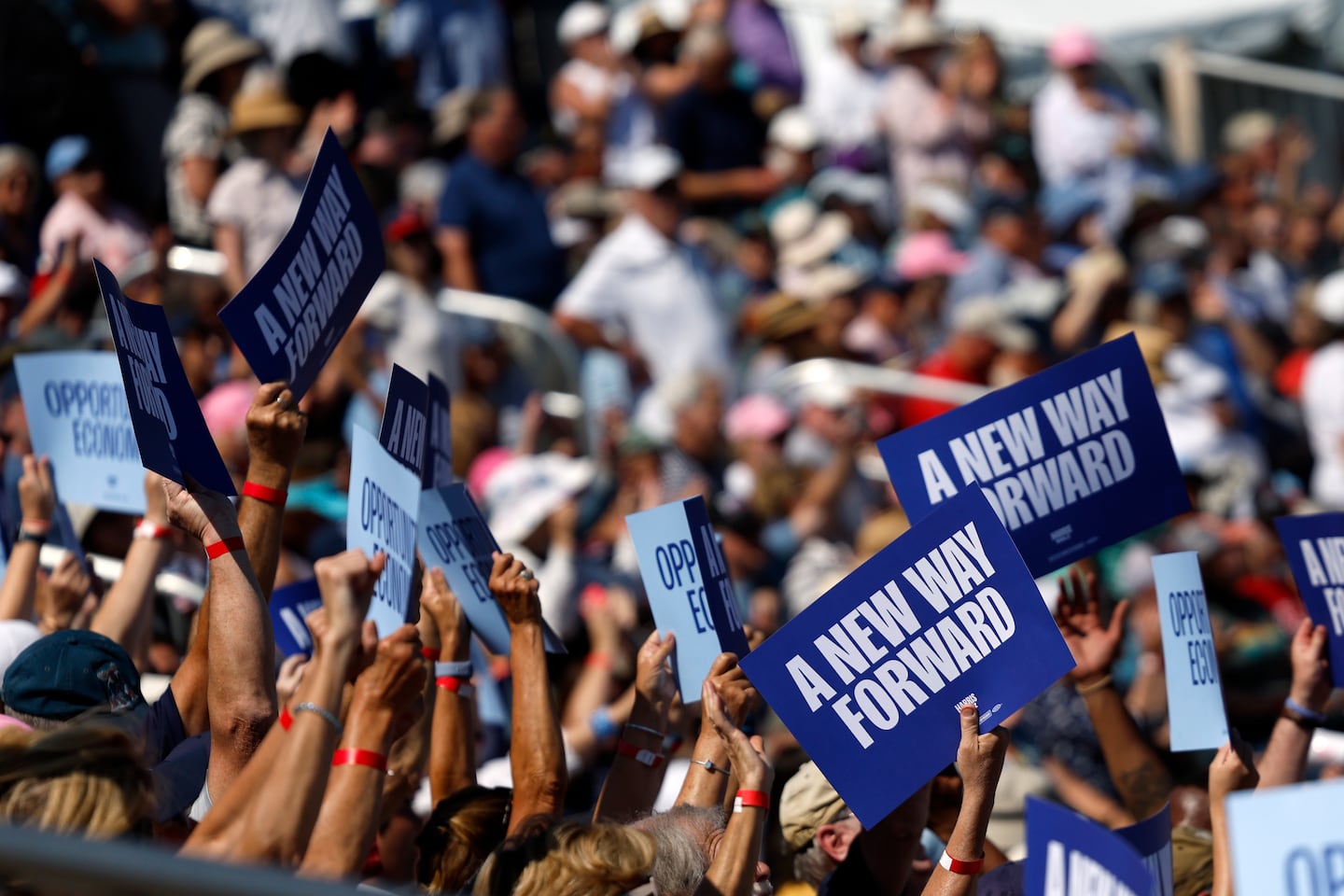 Supporters waved signs at the Harris campaign event at Throwback Brewery on Wednesday. 
