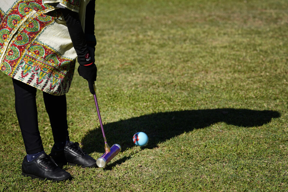 Gateball player Noriko Narita strikes a ball during practice Wednesday, Sept. 4, 2024, at Ala Moana Beach Park in Honolulu. Gateball resembles croquet but requires a different strategy. (Kevin Fujii/Civil Beat/2024)