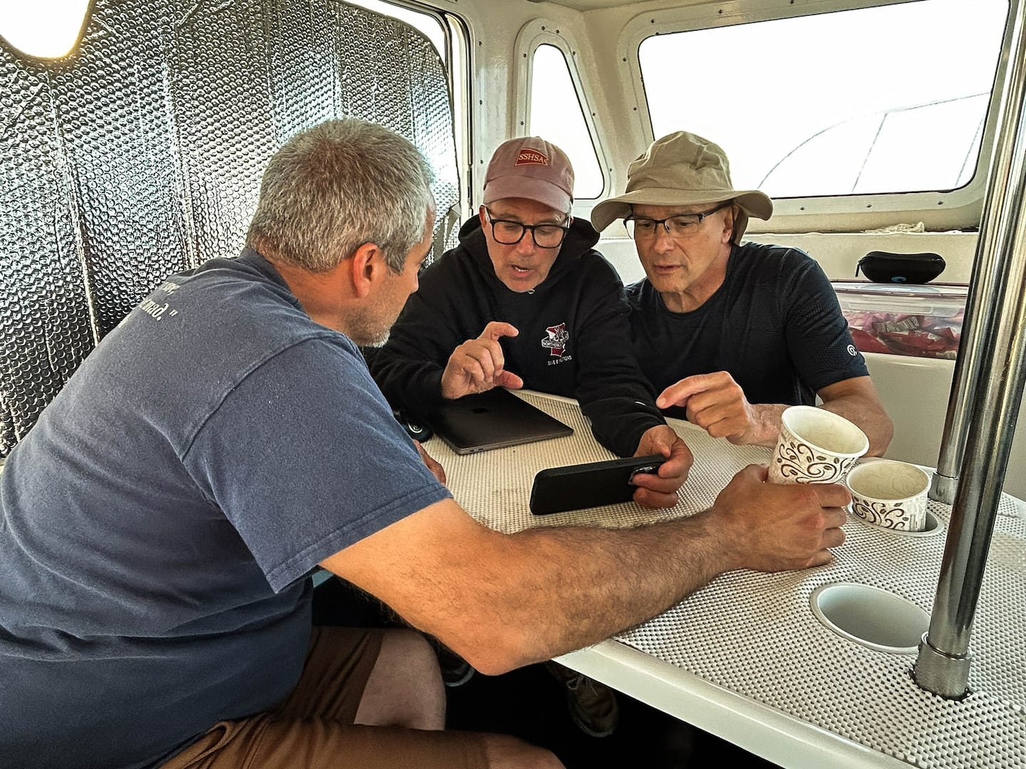 Joe Mazraani, Eric Takakjian, and Tom Packer reviewed video of the ocean floor between dives.