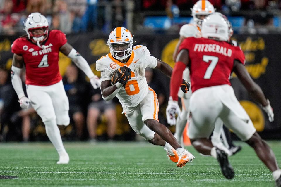 Sep 7, 2024; Charlotte, North Carolina, USA; Tennessee Volunteers running back Dylan Sampson (6) runs as North Carolina State Wolfpack safety Bishop Fitzgerald (7) defends during the second half at the Dukes Mayo Classic at Bank of America Stadium. Mandatory Credit: Jim Dedmon-Imagn Images