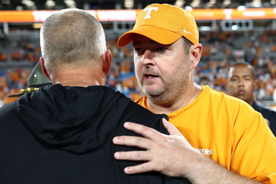 CHARLOTTE, NORTH CAROLINA - SEPTEMBER 07: Head coach Josh Heupel (R) of the Tennessee Volunteers and head coach Dave Doeren of the NC State Wolfpack shake hands following the Duke's Mayo Classic at Bank of America Stadium on September 07, 2024 in Charlotte, North Carolina. The Tennessee Volunteers defeated the NC State Wolfpack 51-10. (Photo by Jared C. Tilton/Getty Images)