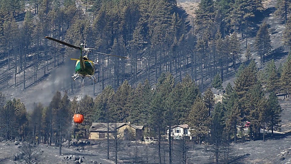 A helicopter transports water in order to fight the Davis Fire in the Washoe Valley, south of Reno. - Jason Bean/Reno Gazette Journal/Imagn Images