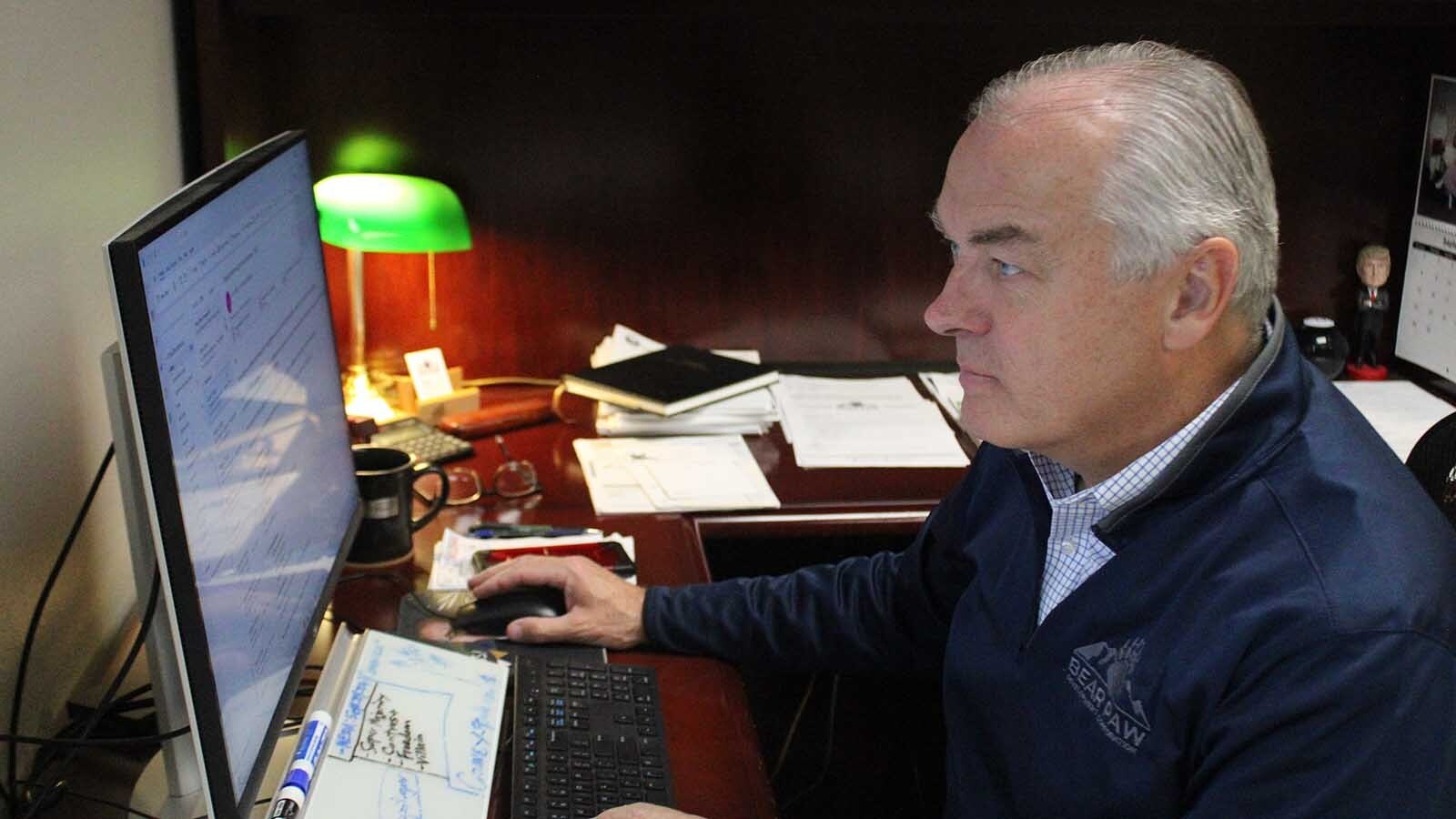 Montana state Rep. Paul Tuss, D-Havre, works in his office as a former President Donald Trump bobblehead watches from the background, right.