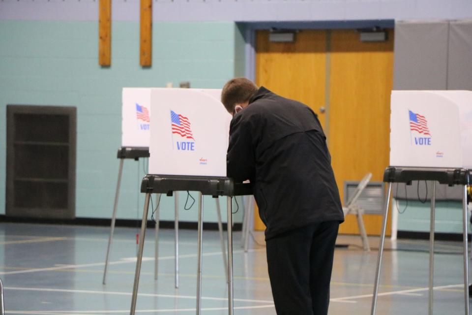 A man votes during the 2020 General Election at a vote center inside Stephen Decatur Middle School in Berlin. Each voting booth was wiped down using a sanitization spray by election workers after a vote used it.