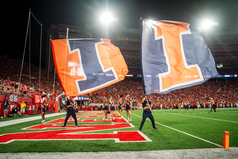 Sep 20, 2024; Lincoln, Nebraska, USA; Illinois Fighting Illini flags are waved after a touchdown against the Nebraska Cornhuskers during the fourth quarter at Memorial Stadium. Mandatory Credit: Dylan Widger-Imagn Images