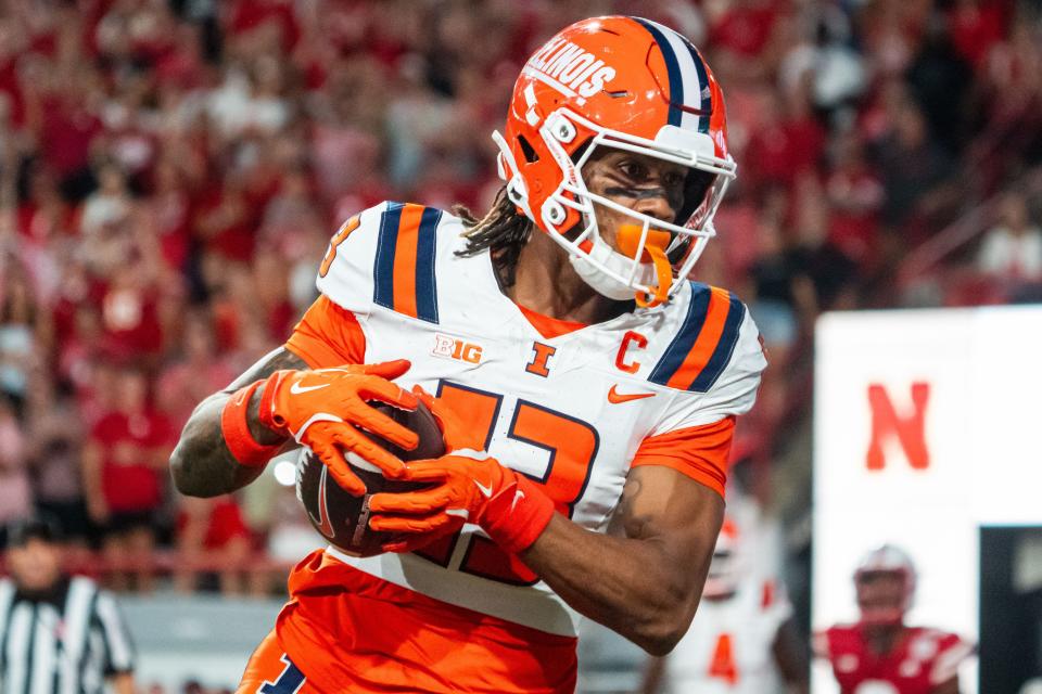 Sep 20, 2024; Lincoln, Nebraska, USA; Illinois Fighting Illini wide receiver Pat Bryant (13) scores a touchdown in overtime against the Nebraska Cornhuskers at Memorial Stadium. Mandatory Credit: Dylan Widger-Imagn Images