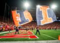 Sep 20, 2024; Lincoln, Nebraska, USA; Illinois Fighting Illini flags are waved after a touchdown against the Nebraska Cornhuskers during the fourth quarter at Memorial Stadium. Mandatory Credit: Dylan Widger-Imagn Images