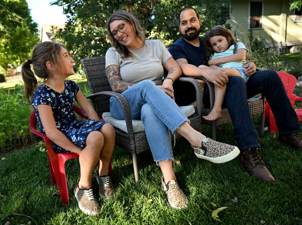 Naomi, 7, left, her mother Brittany, father Orlando and little sister MJ, 4, sit together on their front lawn outside of their home in Denver on Sept. 17, 2024. (Photo by Helen H. Richardson/The Denver Post)