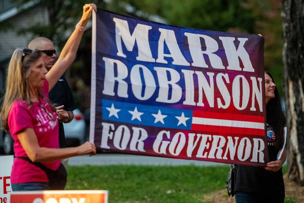 Supporters hold a sign as Mark Robinson takes the stage at his rally in Burnsville, September 14, 2024. Angela Wilhelm/Citizen Times / USA TODAY NETWORK via Imagn Images