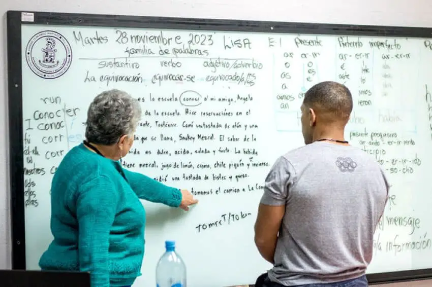 Teacher teaching Spanish verb conjugation to a foreigner