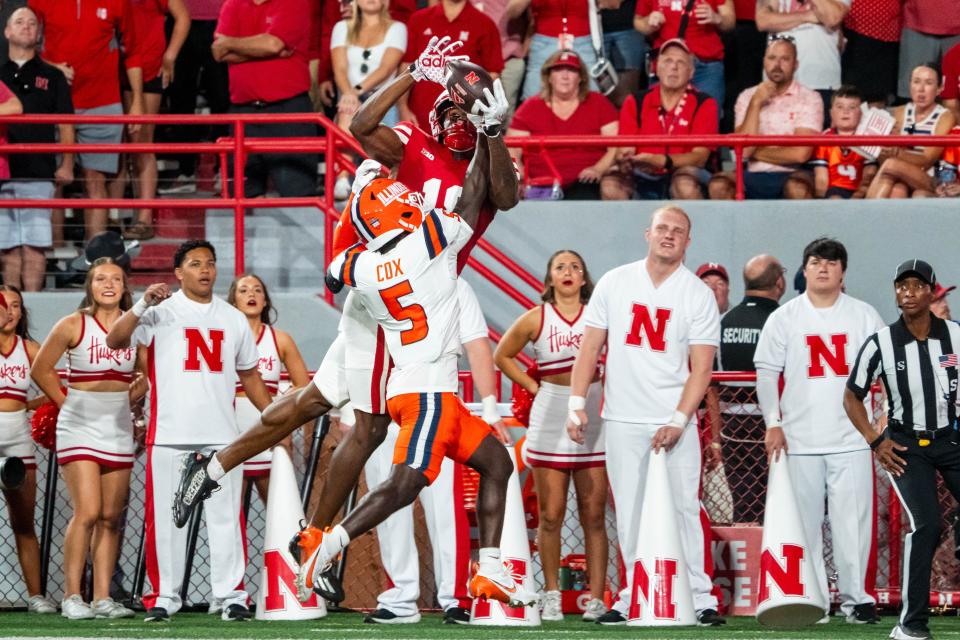 Sep 20, 2024; Lincoln, Nebraska, USA; Illinois Fighting Illini defensive back Torrie Cox Jr. (5) intercepts a pass to Nebraska Cornhuskers wide receiver Isaiah Neyor (18) during the second quarter at Memorial Stadium. Mandatory Credit: Dylan Widger-Imagn Images