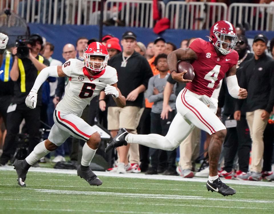 Dec 2, 2023; Atlanta, GA, USA; Alabama Crimson Tide quarterback Jalen Milroe (4) runs for a first down with Georgia Bulldogs defensive back Daylen Everette (6) pursuing at Mercedes-Benz Stadium. Alabama defeated Georgia 27-24 to claim the SEC Championship. Mandatory Credit: Gary Cosby Jr.-USA TODAY Sports