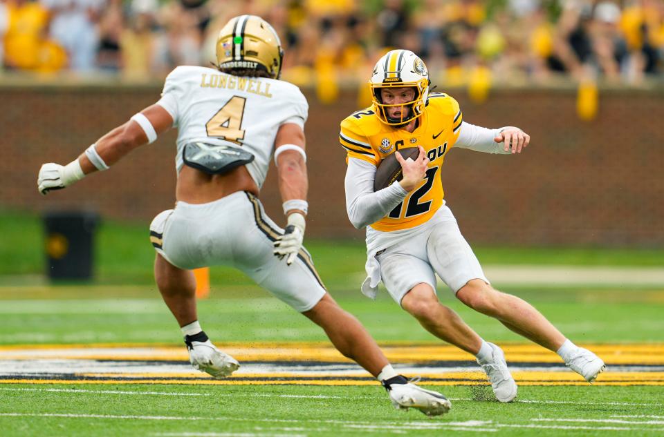 Sep 21, 2024; Columbia, Missouri, USA; Missouri Tigers quarterback Brady Cook (12) runs the ball against Vanderbilt Commodores linebacker Bryan Longwell (4) during the second half at Faurot Field at Memorial Stadium. Mandatory Credit: Jay Biggerstaff-Imagn Images