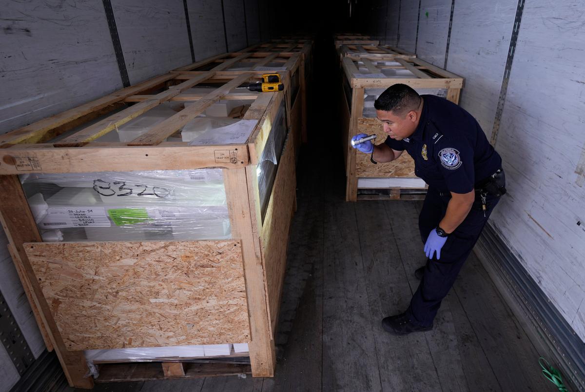 A Customs and Border Protection officer inspects a truck's cargo at the Port of Laredo in Laredo, Texas, on Friday, Aug. 9, 2024.